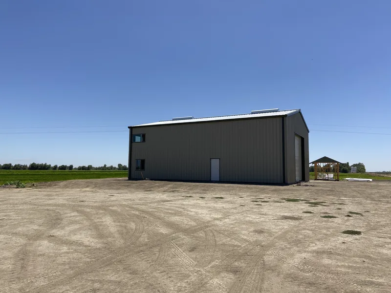 Tall steel barn on open farmland
